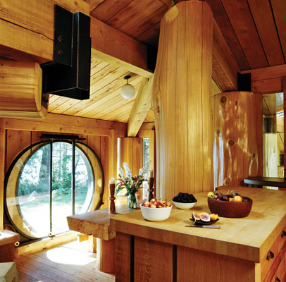 A glazed roof opening throws early morning sunlight into the west-facing kitchen, which opens to the southeast-facing dining room. Mann designed the round door, which was beautifully executed by metalworker Thor Sunde of nearby Vancouver.